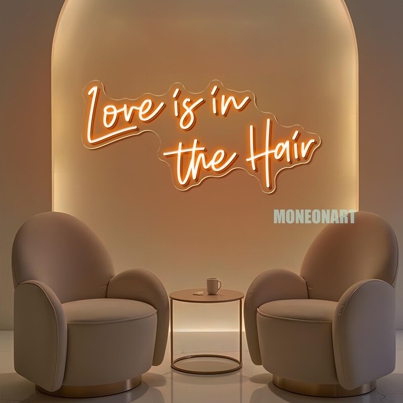 Pu&ograve; includere: Scena d'interni moderna con due poltrone beige, un tavolino rotondo e un'insegna al neon con la scritta "Love is in the Hair". L'insegna &egrave; in un carattere corsivo e si illumina di luce arancione. Una piccola tazza bianca &egrave; sul tavolo.