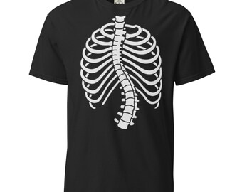 Puede incluir: Camiseta negra con un diseño blanco de caja torácica y columna vertebral esquelética. El gráfico está centrado, sugiriendo un tema de Halloween o médico. La camiseta tiene mangas cortas y cuello redondo.