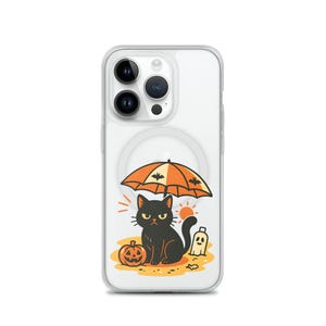 May include: Clear phone case featuring a Halloween-themed illustration. A black cat sits under an orange umbrella with bat silhouettes, next to a carved pumpkin and a ghost. The design is set against a sandy background.
