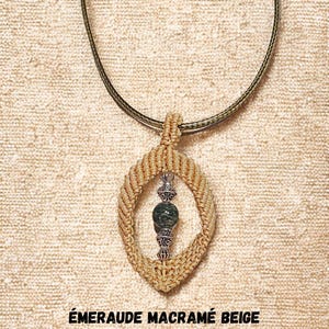 Op de afbeelding: Een beige macramé ketting met een ovale hanger. De hanger heeft een zilverkleurig metalen accent en een groene stenen kraal. Het kettingkoord is donkergroen. De tekst "ÉMERAUDE MACRAMÉ BEIGE" staat onderaan.