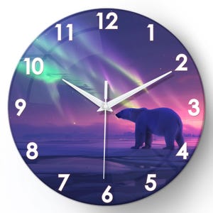 Puede incluir: Reloj de pared redondo con un oso polar frente a una aurora boreal. La esfera del reloj tiene números y manecillas blancas. El fondo muestra tonos de morado, verde y rosa.