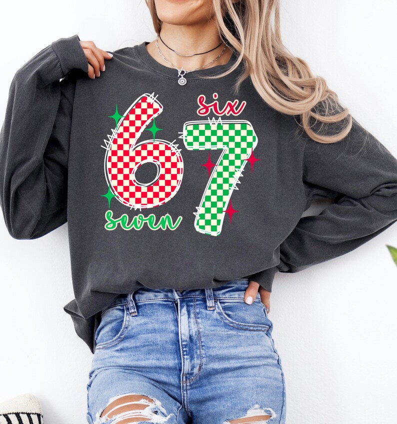 A woman wearing a gray sweatshirt with the number 67 and the text "Six seven" printed on it.