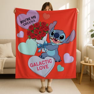 A person holding a red blanket with a cartoon character and a bouquet of red roses.