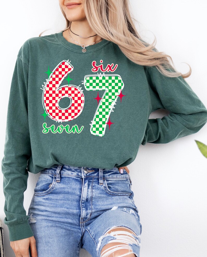 A woman wearing a green long-sleeved shirt with the number 67 and a patterned design, paired with distressed blue jeans.