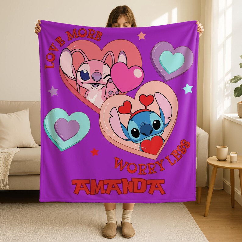A person holding a purple blanket with a cartoon character design and text.
