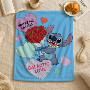 a blue blanket with a cartoon character holding a bouquet of red roses, surrounded by hearts and the text "You're My Ohana" and "Galactic Love".