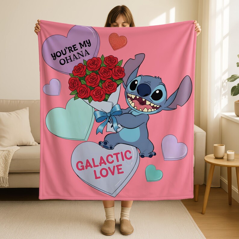 A person is holding up a pink blanket with a cartoon character and a bouquet of red roses. The blanket has a message that says "You're my Ohana" and "Galactic Love".