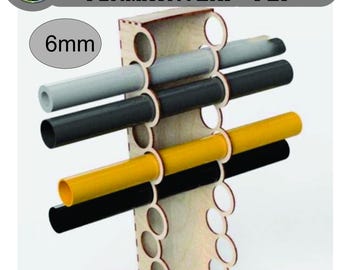May include: A wooden organizer with multiple holes holding various colored tubes. The tubes are gray, black, yellow, and black. The text "VECTOR DESIGNS FORMATR : DXF - PDF" is at the top. The text "6mm" is in a circle.