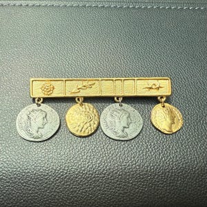 Vintage Pinback Gold tone bar with dangled Coin replicas