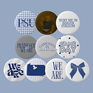 Pode incluir: Uma coleção de dez botões redondos com vários desenhos e texto. Os botões apresentam um esquema de cores azul e branco, com frases como "PSU", "Game Day" e "We Are". Alguns botões têm padrões de xadrez, listras ou estrelas.