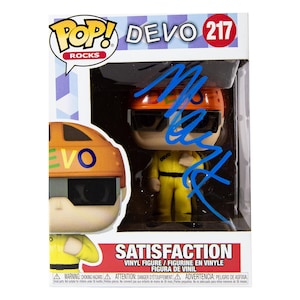 Peut inclure: Figurine Pop! Rocks de Devo, numéro 217, dans son emballage d'origine. La figurine porte une combinaison jaune et un casque orange. La boîte porte le mot "SATISFACTION" et la figurine est signée au marqueur bleu.