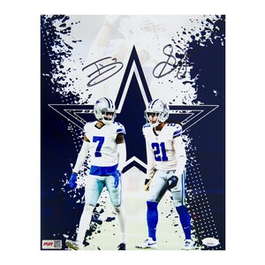 May include: A poster featuring two football players in white and blue uniforms, standing in front of a large star and a blue splatter background. The players are wearing helmets and the poster has two signatures.