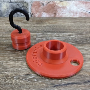 May include: A red plastic base with a hole in the center and the text "edsmake" printed on the side. A black plastic hook is attached to the top of the base.