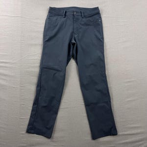 Op de afbeelding: Donkerblauwe broek met een knoopsluiting, riemlussen en voor- en achterzakken. De broek is gemaakt van een gladde, kreukvrije stof. De broek is effen van kleur en heeft een klassiek, rechtbenig ontwerp.
