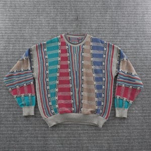 May include: A long-sleeve crew neck sweater featuring a multi-colored vertical striped pattern in shades of teal, red, tan, and blue. The knit garment includes textured panels, ribbed cuffs, and a ribbed hem, with a label at the inner neckline.