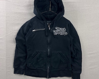 Sudadera con capucha y cremallera Metal Mulisha para mujer, talla grande, color negro, con capucha de sherpa y logotipo de alas en relieve.