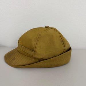 Peut inclure: Une casquette de baseball jaune moutarde avec une calotte structurée et une visière courte et incurvée. La casquette présente un design à plusieurs panneaux avec des coutures visibles le long des jointures et une couleur unie.