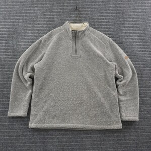 May include: A gray quarter-zip pullover sweater with a textured waffle-knit pattern. The garment features a high collar lined with cream-colored fleece, a central zipper closure, and a small tan patch detail on the left sleeve near the shoulder.