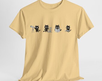 May include: A light yellow t-shirt featuring a graphic of four black cats engaged in various activities: using a telescope, experimenting, reading, and working on a computer. The cats are depicted in a cartoon style.