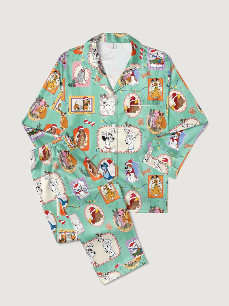 Op de afbeelding: Lichtgroene tweedelige pyjamaset met een herhalend patroon van verschillende hondenrassen in feestelijke kaders. De pyjama heeft witte biezen en een overhemd met knopen en kraag.