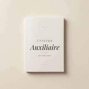 Peut inclure: Un livre crème intitulé "Cerveau Auxiliaire" avec le sous-titre "A system to lighten the mental load." La couverture présente le texte dans une police serif élégante. Le livre est une "MOM EDITION" et provient de l'éditeur "TAZARTEEDITION".