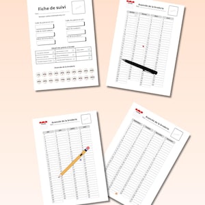 Puede incluir: Cuatro hojas de papel blancas con texto y gráficos, incluyendo "Fiche de suivi" y "Avancée de la broderie". Una hoja tiene un bolígrafo, otra un lápiz y las otras están en blanco. El fondo es de color melocotón claro.