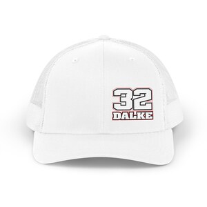 Peut inclure: Une casquette trucker blanche avec un arrière en filet et un panneau avant solide. L'avant affiche le nombre 32 dans une police grasse à contour noir au-dessus du texte DALKE, également en police grasse à contour noir avec un fin trait rouge.