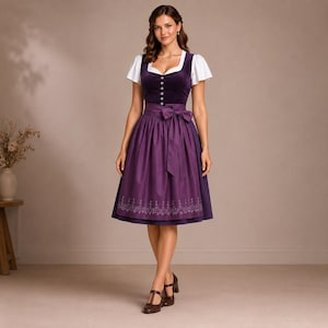 May include: A dark purple dirndl dress featuring a velvet bodice with a row of silver buttons, short white puff sleeves, and a matching purple apron with a bow at the waist. The skirt has a subtle embroidered pattern along the bottom hemline.