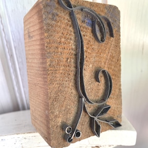 Peut inclure: Un bloc d'impression typographique vintage. Le bloc en bois présente la lettre "E" en métal dans un style orné. Le bois a un aspect vieilli et le métal est sombre. Idéal pour l'impression.