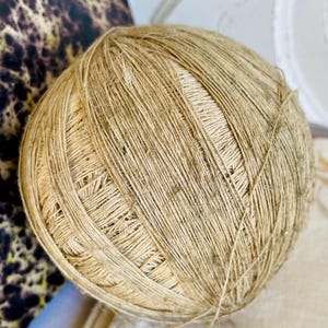 Peut inclure: Une grosse pelote de ficelle naturelle, composée de fibres brun clair étroitement enroulées. La ficelle est parfaite pour l'artisanat, le jardinage et d'autres projets de bricolage.