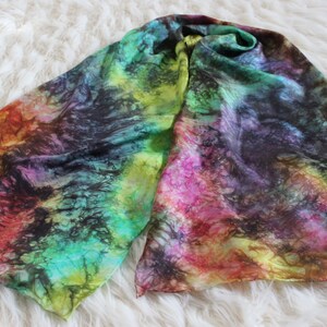 May include: A colorful silk scarf with a tie-dye pattern in shades of green, yellow, pink, red, and black.