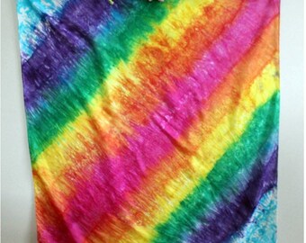 May include: A colorful tie-dye fabric square with a rainbow pattern in shades of purple, green, yellow, orange, and pink.