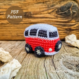 May include: A crocheted red, white, and black camper van with white wheels. The van has a white roof and black windows. The image includes the text "PDF Pattern" and "CrochetCamperLife".