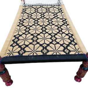 May include: A woven bed frame with a black and tan geometric pattern. The bed has four decorative legs with red and brown painted details. The headboard has a white woven section.