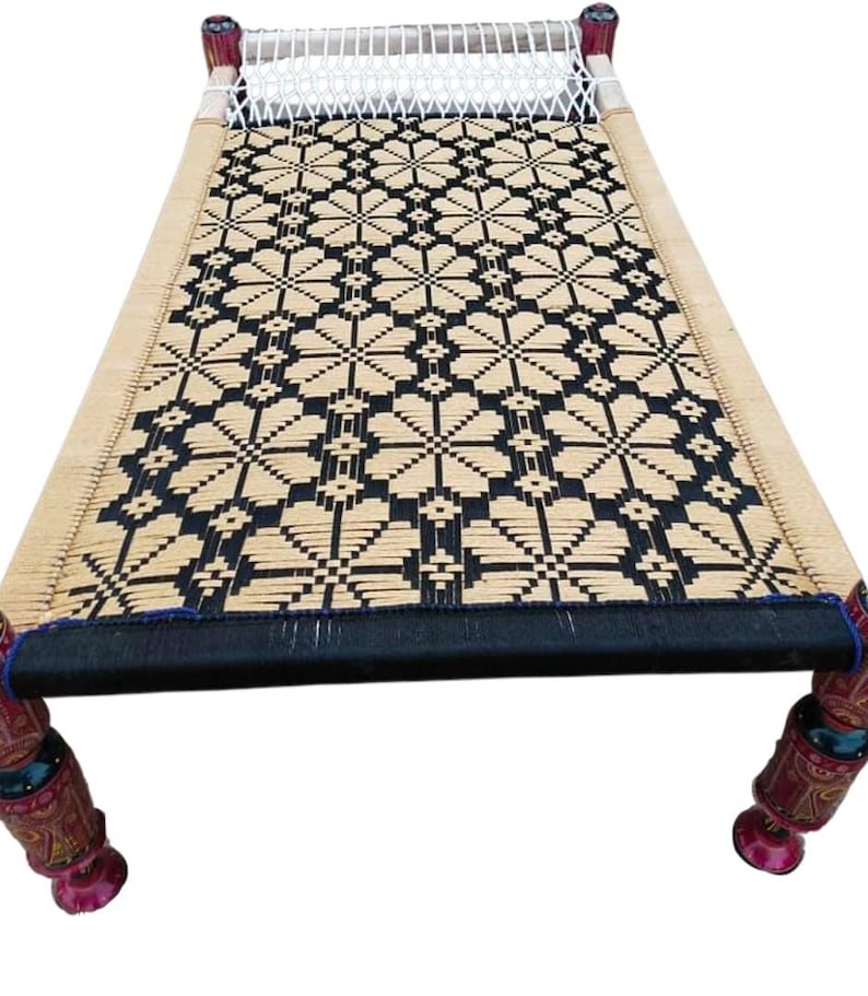 May include: A woven bed frame with a black and tan geometric pattern. The bed has four decorative legs with red and brown painted details. The headboard has a white woven section.