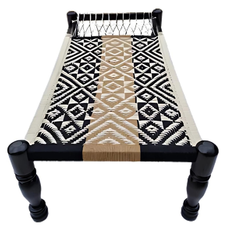 May include: A woven daybed with a geometric pattern in black, white, and tan. The bed frame is black with turned legs. The woven surface is approximately 72 inches long.