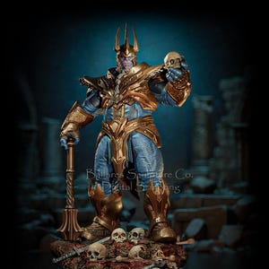Puede incluir: Estatua detallada de un personaje de piel púrpura con armadura dorada, sosteniendo una calavera y un bastón. La figura se alza sobre una base de calaveras y espadas. La estatua tiene una expresión amenazante y un fondo oscuro.