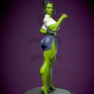 May include: A green She-Hulk statue wearing a white shirt and blue shorts, holding glasses. The statue is on a round base with the words "SHE HULK" in green and purple.