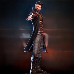 May include: A figurine of a man in a long black coat, gray jeans, and black boots, holding a weapon. The figure has a stern expression and a dark beard. The background is a gradient of dark blue and orange.