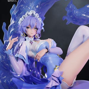 Op de afbeelding: Gedetailleerd beeldje van een personage met lavendelkleurig haar en een blauw-witte jurk. De figuur poseert met een dynamisch, vloeiend waterachtig effect op de achtergrond. De tekst "WUTHERING WAVES" is zichtbaar linksboven.