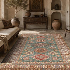 Peut inclure: Un tapis rectangulaire présentant un fond bleu sarcelle avec un motif répétitif de médaillons géométriques dans des tons de rouge, crème et bleu marine. Le tapis possède une large bordure complexe avec des motifs floraux et géométriques assortis.