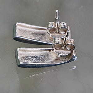 Back view of sterling silver rectangular stud earrings with butterfly backs