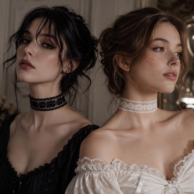 May include: Two women wearing lace chokers. One choker is black with a floral design, and the other is white. The women are in a room with soft lighting, and they are wearing dark and light-colored tops.