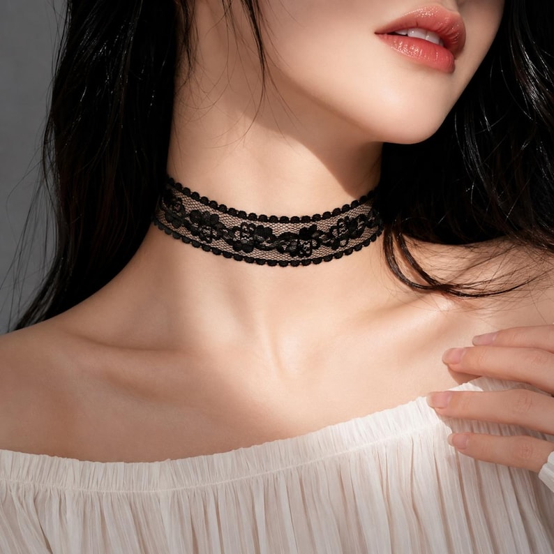 May include: A black lace choker necklace with a floral design. The choker is worn around the neck and is made of delicate lace. The background is a neutral color.