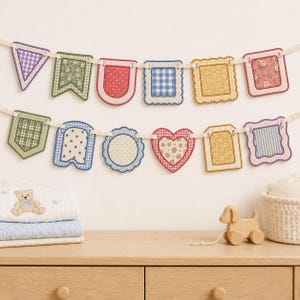 May include: A decorative fabric bunting banner featuring two rows of hanging pennants in various shapes and patterns, including gingham, floral, polka dot, and star prints in shades of blue, green, yellow, red, and purple, suspended on a cream ribbon.