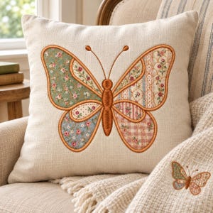 Puede incluir: Un cojín cuadrado de color beige con un gran diseño de mariposa bordado. Las alas de la mariposa están divididas en secciones con varios patrones florales, de rayas y de cuadros en tonos verde, azul, rosa y crema, delineados en marrón.