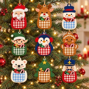 May include: A set of nine felt Christmas ornaments featuring characters including Santa, a reindeer, a snowman, an elf, a penguin, a gingerbread person, a polar bear, a tree, and a nutcracker, each with a gingham pocket holding candy.