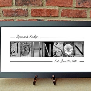 May include: Black framed print with the name "JOHNSON" spelled out in black and white images. The names "Ryan and Kaitlyn" and the date "Est. June 26, 2016" are above and below the name.