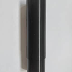 Op de afbeelding: Een zwart cilindrisch object met een iets kleinere cilinder aan de onderkant. Het object heeft verticale lijnen en een witte lijn langs de zijkant. Op een witte achtergrond.