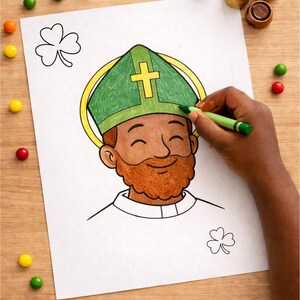 May include: A St. Patrick's Day colouring page featuring a figure with a green hat and gold halo. A hand is colouring the hat with a green crayon. Colourful sweets and chocolate candies are scattered around.